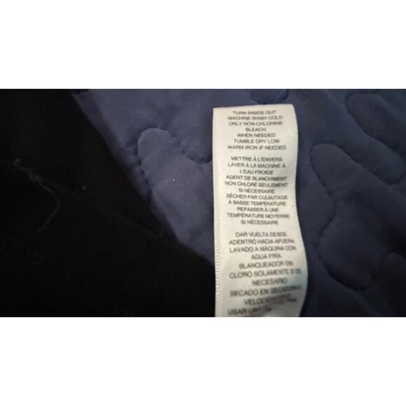 Michael Kors black t-shirt featuring a large, vertical metallic silver logo. - Picture 3 of 7